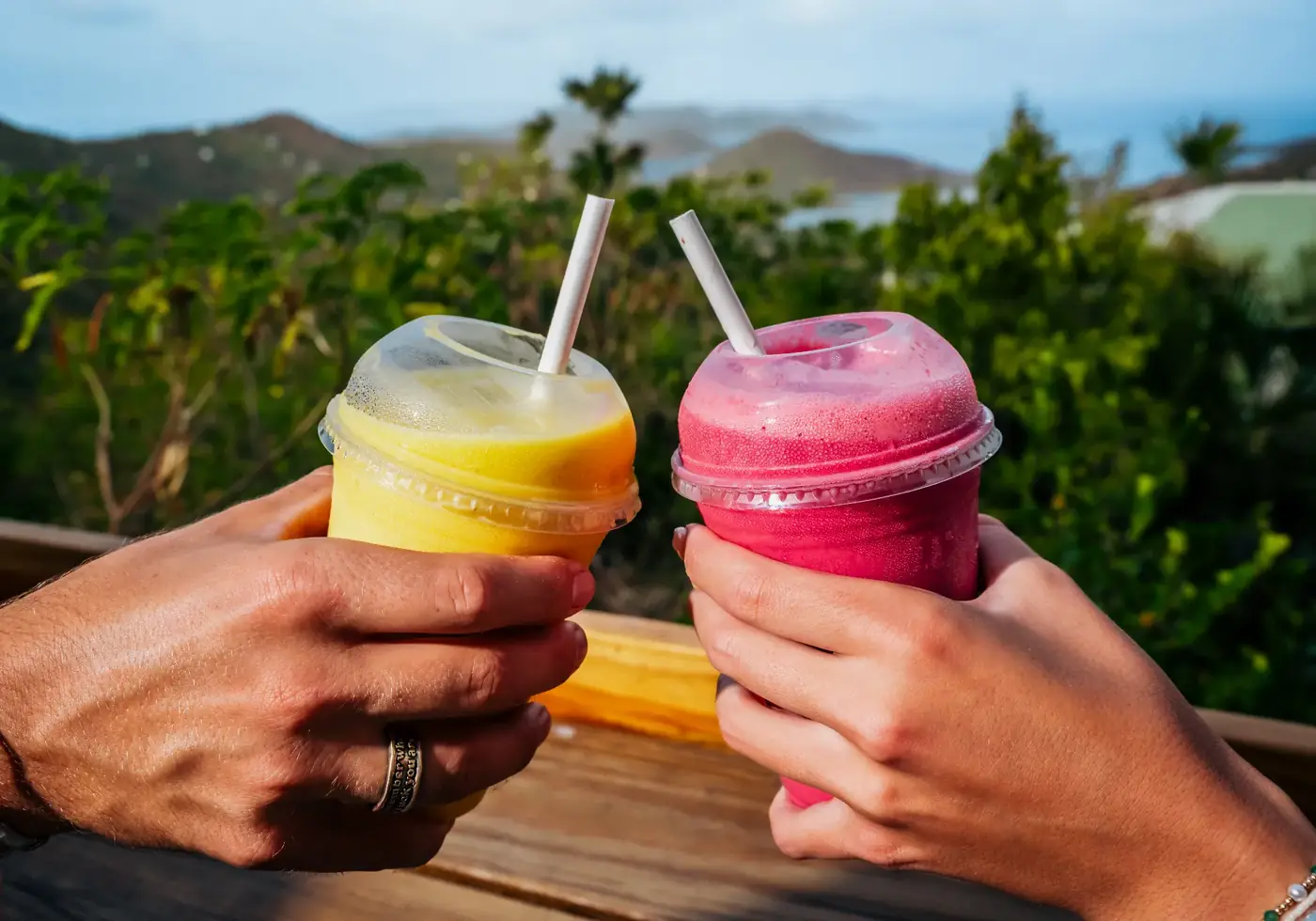 Two guests toasting with Drifters smoothies at the hilltop deck